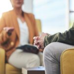 Man hands, Close-up of a therapy session, showing two people seated and engaged in conversation