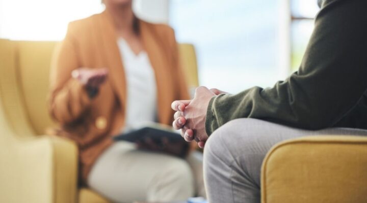 Man hands, Close-up of a therapy session, showing two people seated and engaged in conversation