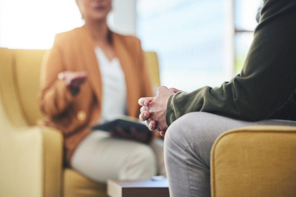 Man hands, Close-up of a therapy session, showing two people seated and engaged in conversation