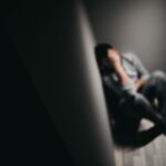 sad person sitting in a corner upset