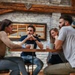 Four friends sit at a table in a cozy café, engaged in a serious conversation over coffee.